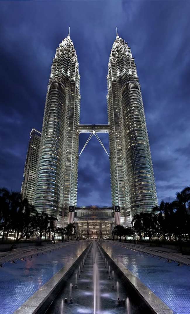 1. Tòa tháp đôi Petronas

Công trình kiến trúc nổi tiếng đầu tiên phải kể đến nằm ở Kuala Lumpur, Malaysia. Đó chính là tòa tháp Petronas hay còn có tên gọi khác là tháp đôi Petronas. Từ năm 1998 – 2008, Petronas là tòa tháp cao nhất trên thế giới. Chúng cũng là dấu ấn của thành phố Kuala Lumpur. Hai tòa tháp xinh đẹp này được thiết kế bởi kiến trúc sư người Argentina César Pelli và đi theo phong cách hậu hiện đại, đơn giản nhưng táo báo.
