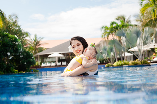 Trang trần hạnh phúc khoe đường cong bên bể bơi cùng con gái