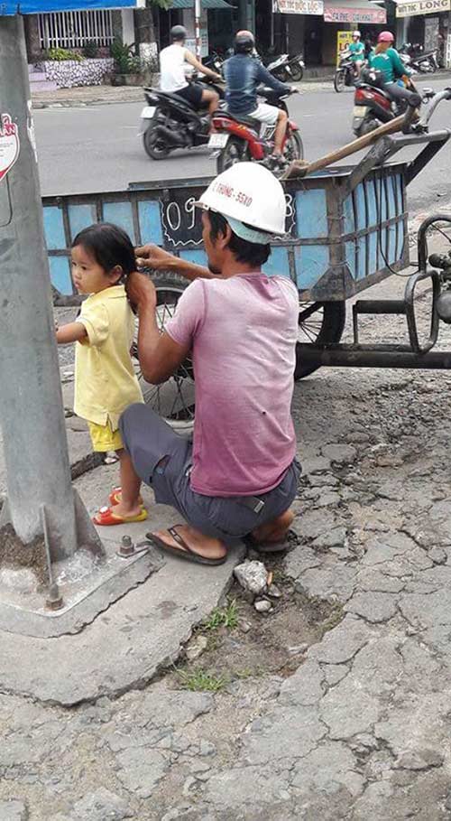 Bức ảnh người bố công nhân buộc tóc cho con gái khiến cư dân mạng tan chảy